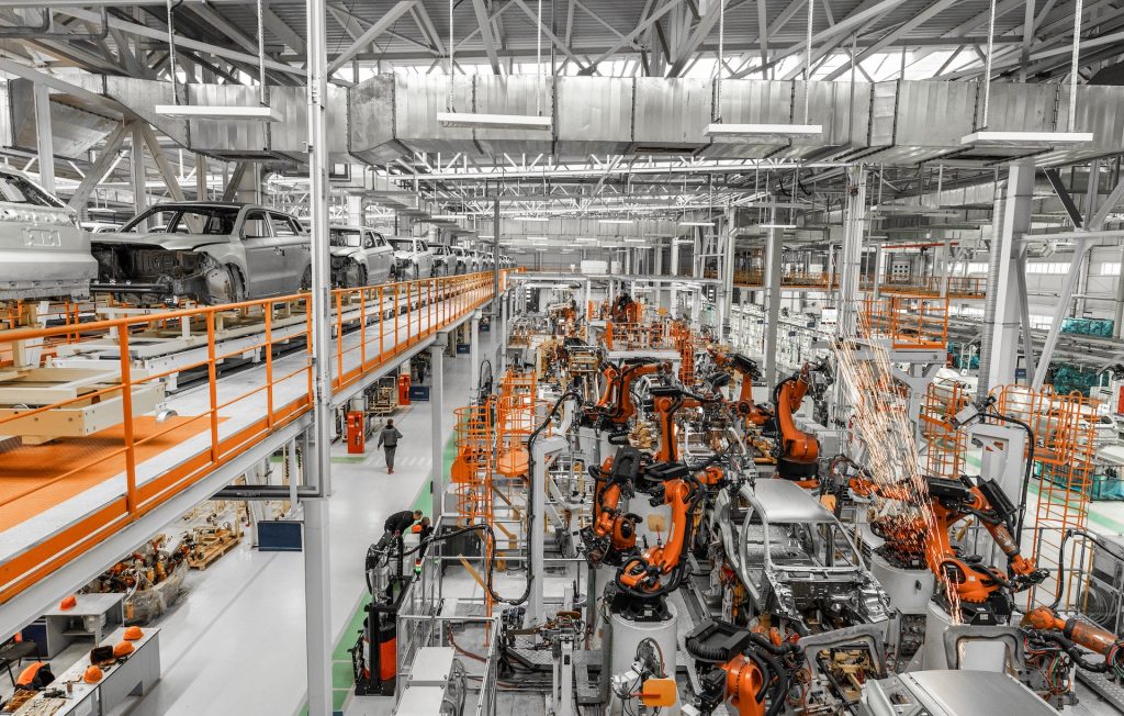 Modern car production line with robotic arms welding vehicle bodies in an automotive assembly plant